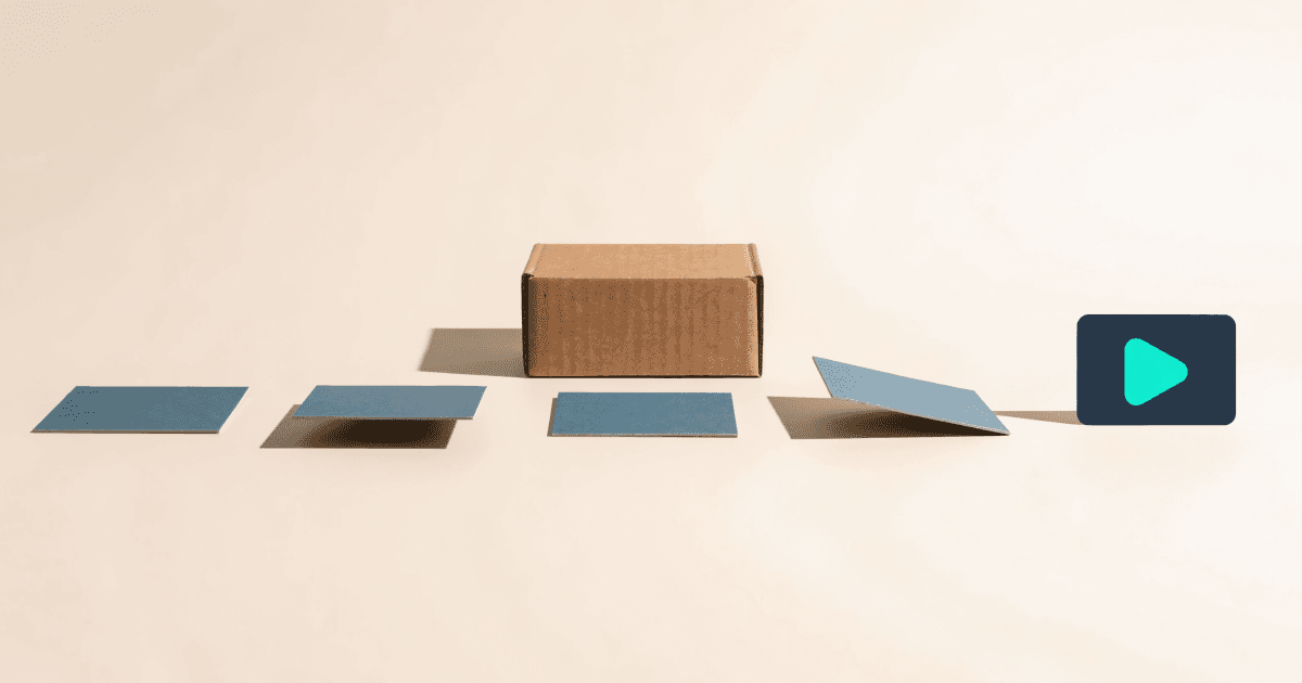 A brown shipping box sits on a cream surface with a path of blue cards leading to a dark device screen displaying a teal play button icon.